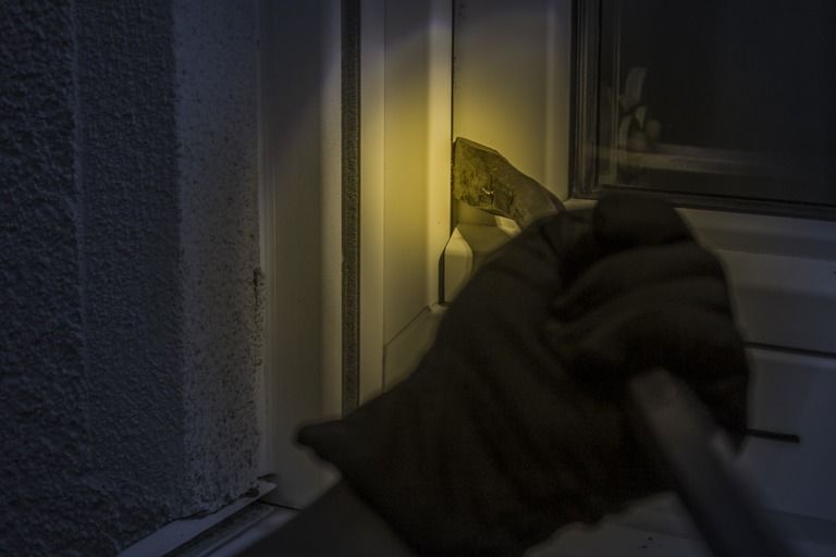 burglar opening window at night